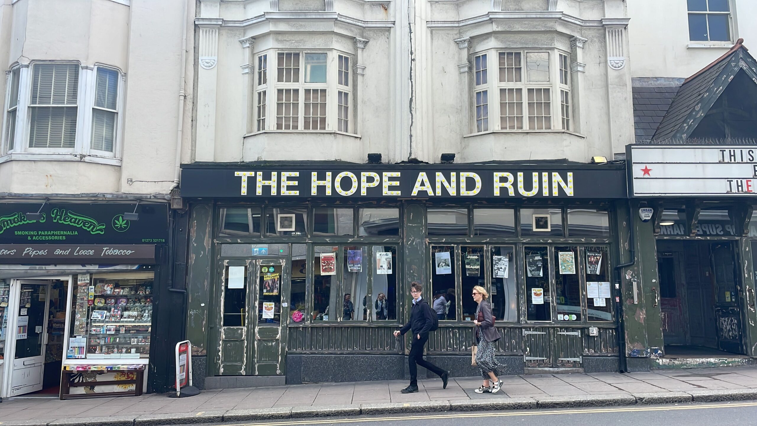 Kneipe oder Laden mit der Beschriftung "The Hope and the Ruin", 2 Passanten davor