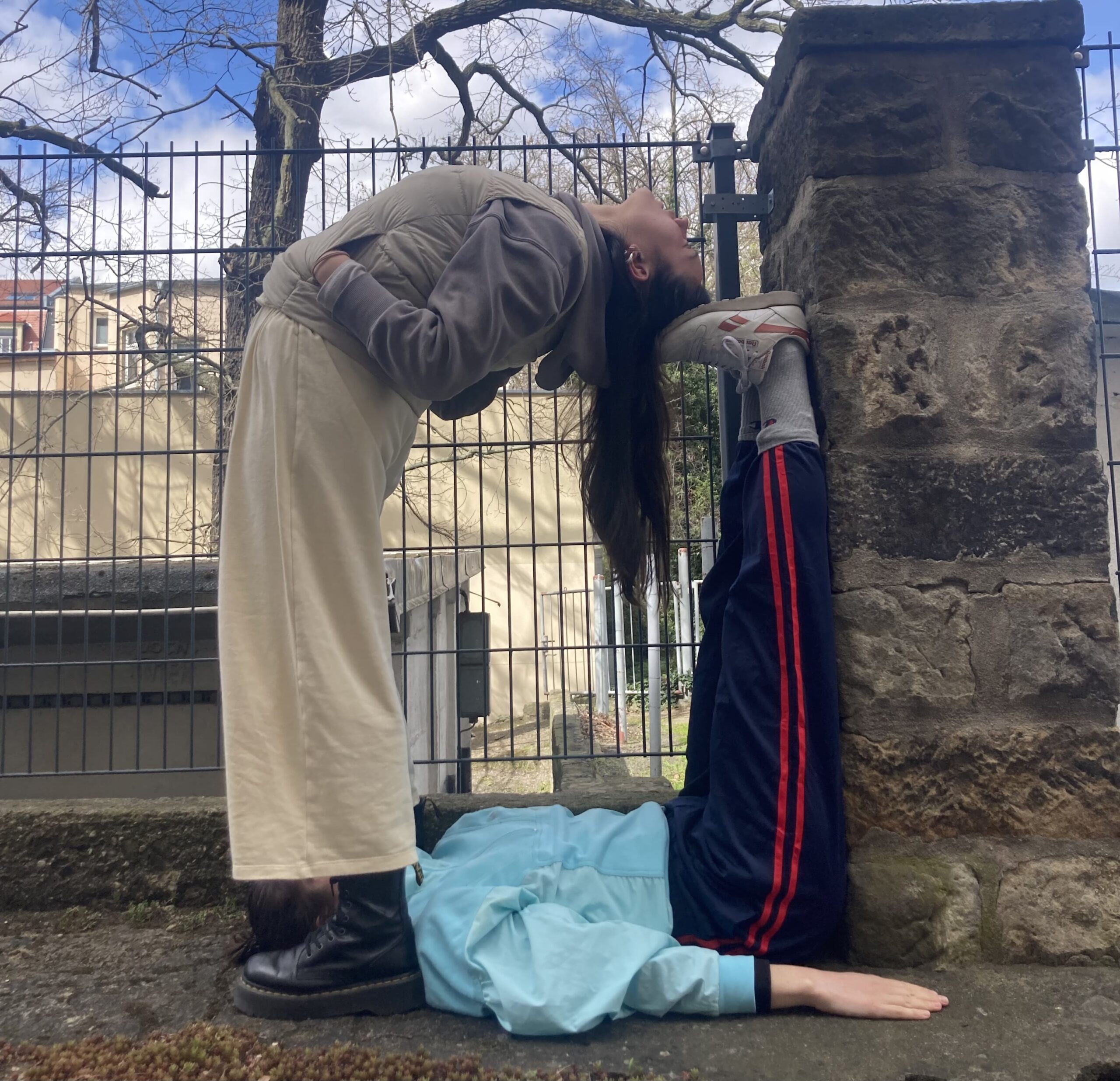 2 Menschen lehnen an einer Mauer