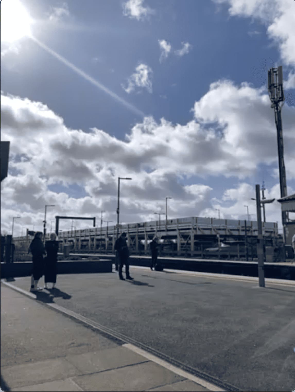 Bahnsteig mit Himmel und wartenden Personen